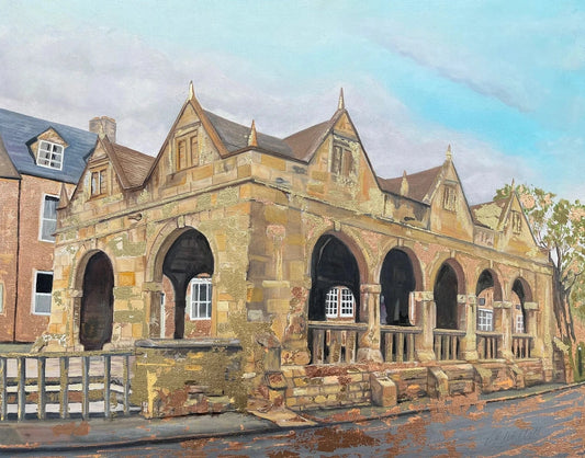 An oil painting of a historic stone building with arched openings, gabled rooflines, and a wet street in the foreground under a blue sky.